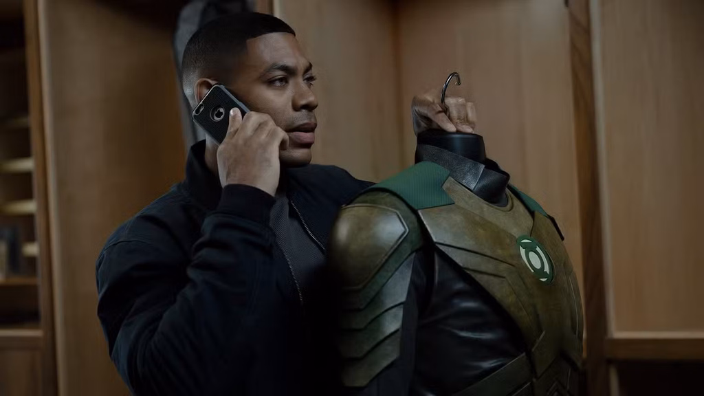 John Stewart Lanterns image showing John holding his Green Lantern uniform while talking on his phone.